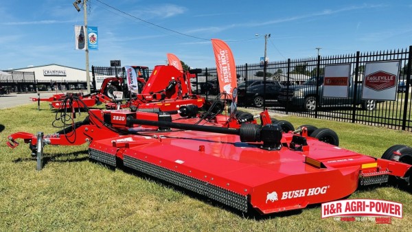 Bush Hog rotary cutters displayed on grass at an equipment dealership.