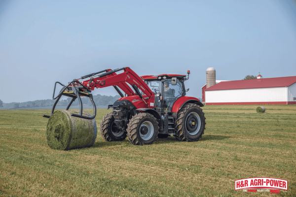 Case IH tractor handling a round hay bale, representing durability, maintenance, and long-lasting equipment performance