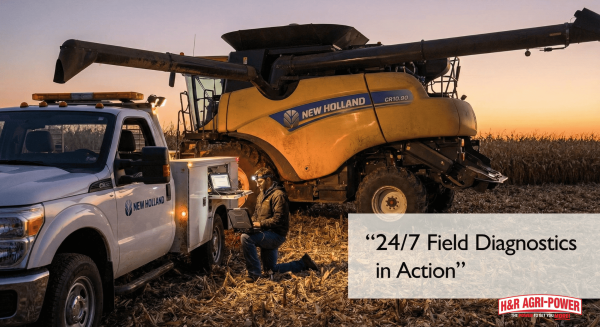 Technician using diagnostics tool next to a New Holland harvester during emergency field repair.
