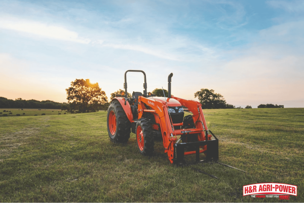 Compact Kubota tractor with front loader on open farmland, highlighting affordable Kubota financing solutions for small and mid-sized Illinois farms.