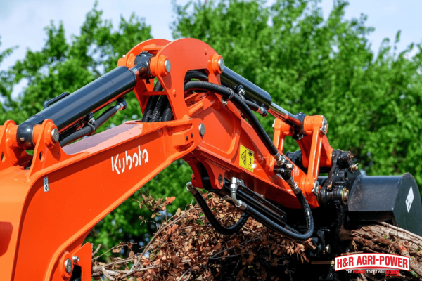 Close-up of Kubota compact excavator hydraulic arm and bucket attachment in operation