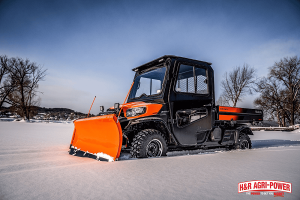 Kubota RTV with enclosed cab and snow plow improving operator safety and machine performance in winter conditions
