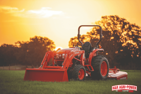 Kubota tractor on a field at sunset representing reliable performance and maintenance readiness