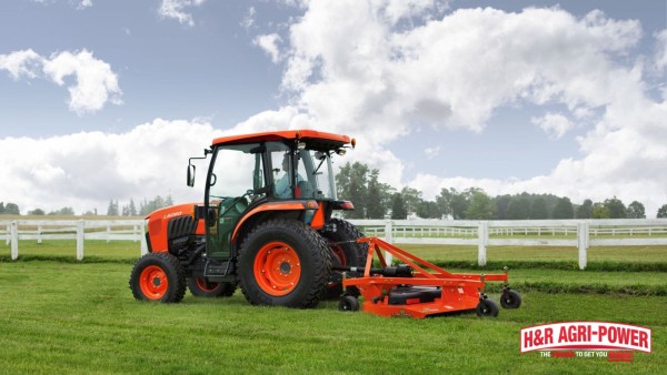 Kubota tractor pulling a finish mower across maintained grass on level terrain