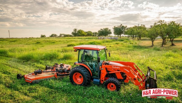 Kubota tractor using a Land Pride rotary cutter to mow thick grass on rural acreage