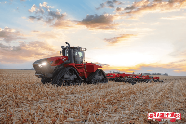 Case IH tracked tractor working a field at sunset, representing performance comparison between Kubota and Case IH equipment warranties