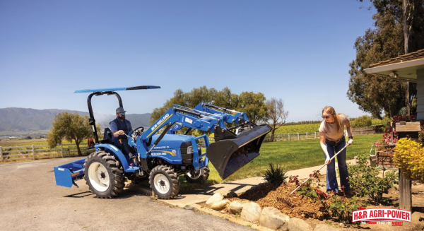 New Holland compact tractor with front loader assisting homeowner landscaping project