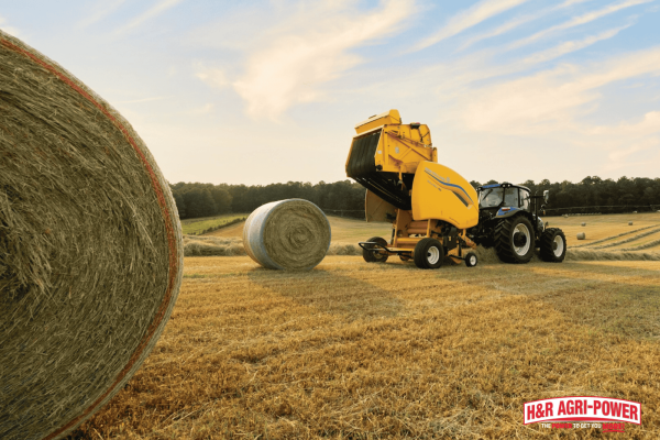 New Holland round baler producing hay bales in the field, highlighting proper maintenance practices for efficient operation