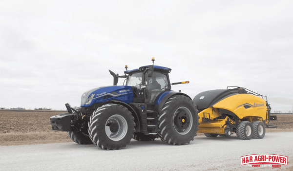 New Holland tractor with baler attachment in field representing proper maintenance for longer equipment lifespan