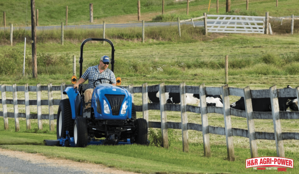 New Holland tractor operating near livestock area representing reliable dealer support and maintenance access