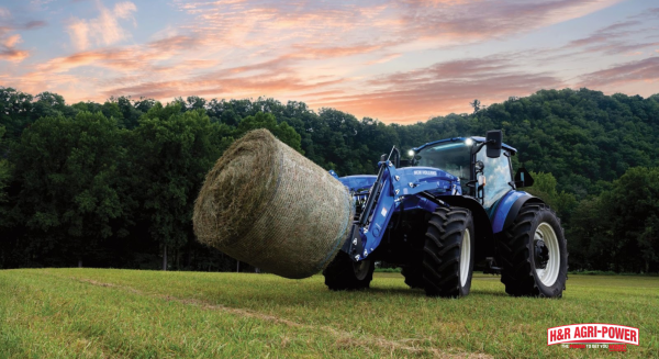 New Holland utility tractor handling round hay bale, emphasizing maintenance reliability and dealer support