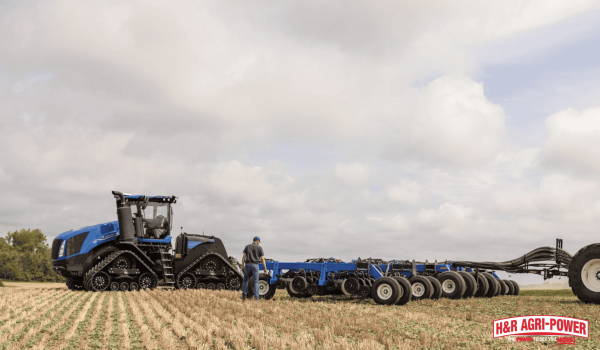 New Holland tracked tractor pulling seeding equipment in field illustrating farm equipment investment and budget planning