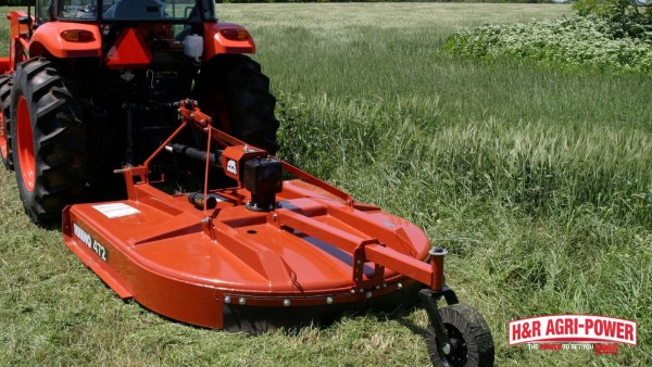 Rhino rotary cutter attached to a tractor showing PTO driveline compatibility in tall grass