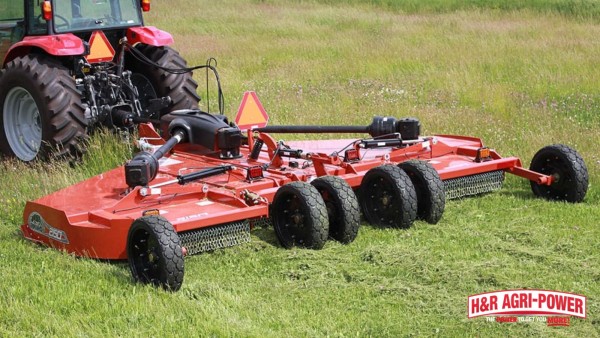 Tractor pulling a Rhino rotary cutter with visible PTO driveline and deck components