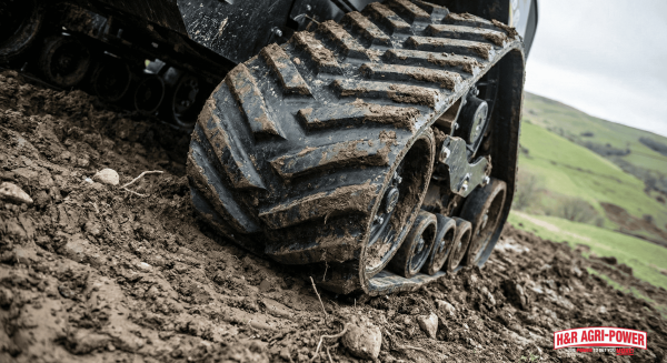 SmartTrax™ rubber tracks gripping into wet, muddy hillside.