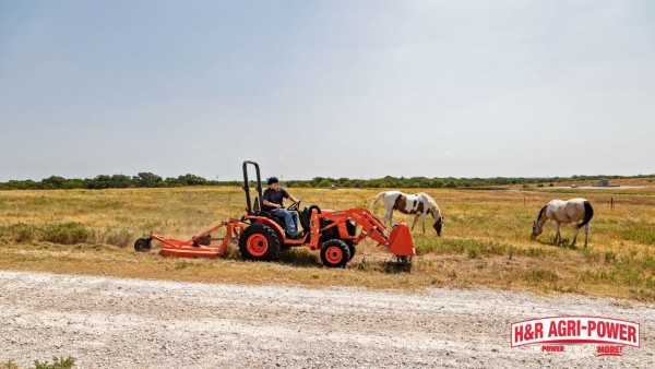 Tractor brush hogging an open pasture while maintaining grass cover for soil conservation