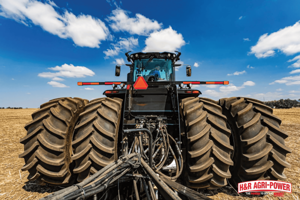 Rear view of tractor with dual tires and visible hydraulic connections, showing components affected by air in hydraulic systems