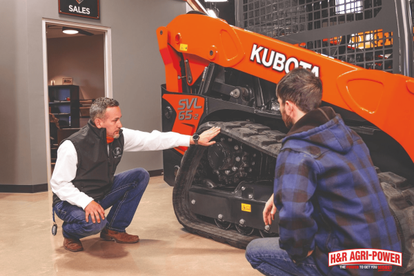 Kubota technician inspecting engine and track components during routine maintenance to prevent moisture-related issues in Mississippi’s humid climate.