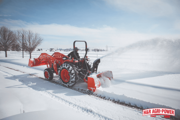 Kubota tractor clearing snow with a front-mounted snow blower during winter conditions in Indiana